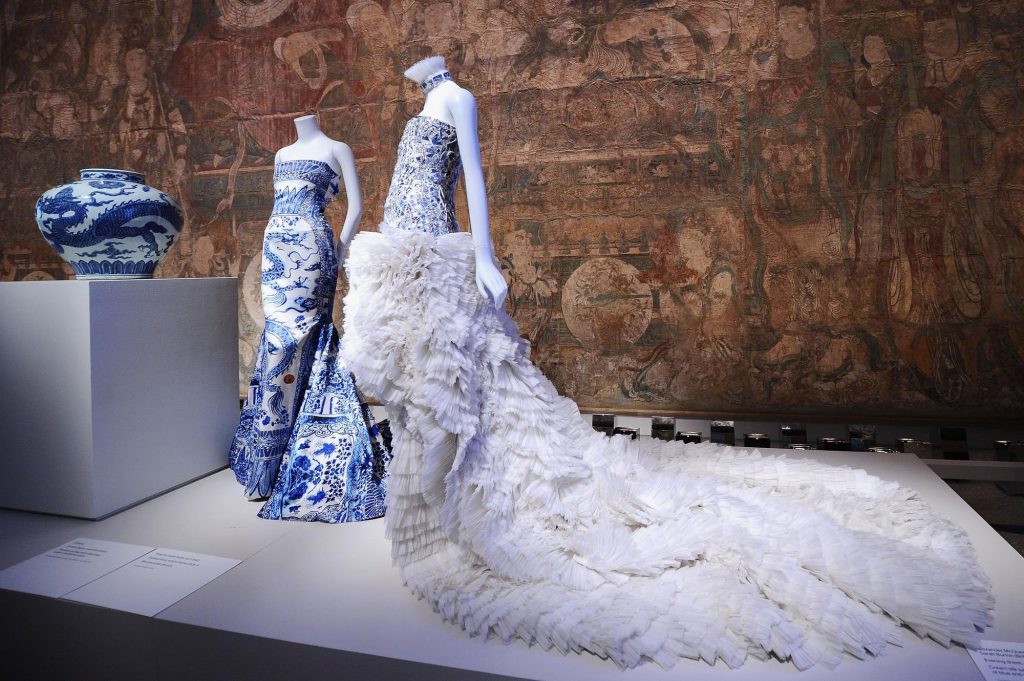 Blue dragon print dress by Roberto Cavalli and blue dress with a white train by Alexander McQueen, Image Courtesy of Andrew Toth at Getty
