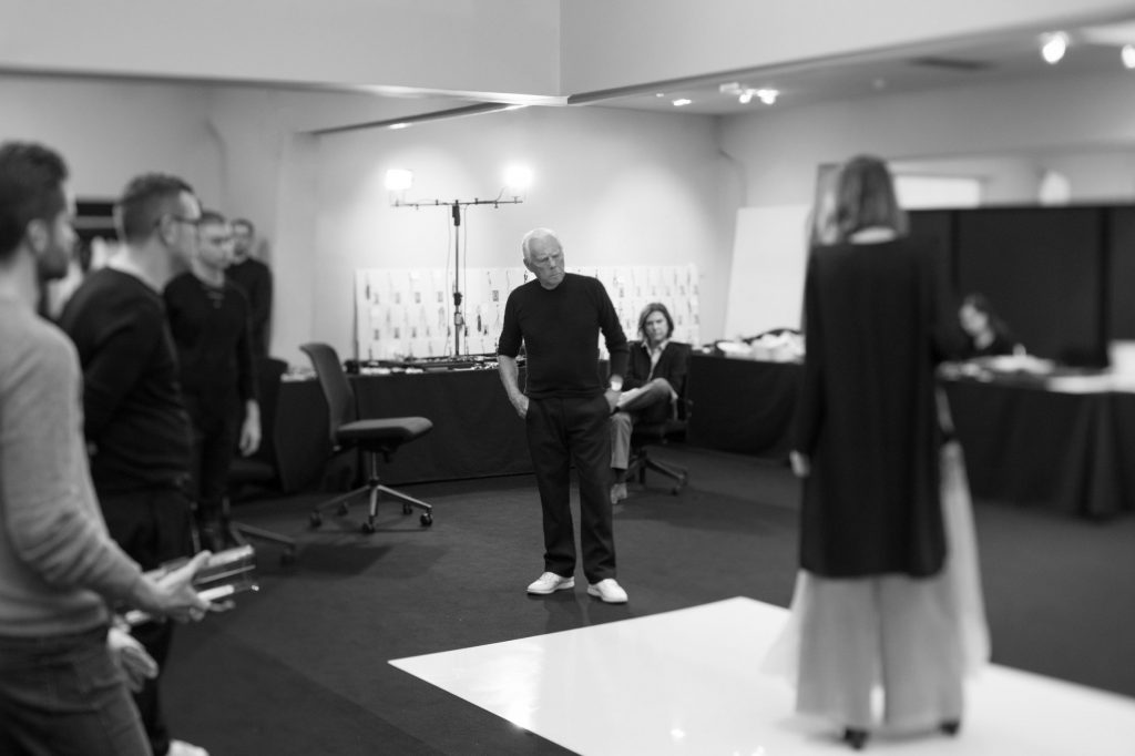 Designer Giorgio Armani backstage for a fitting before the show.