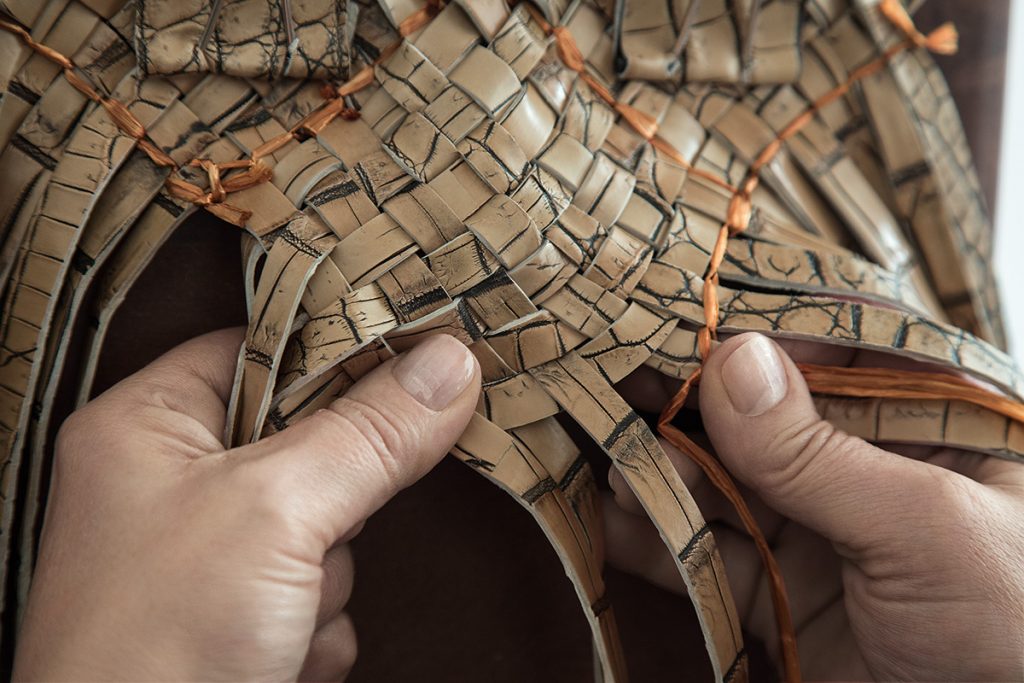An Italian artisan handcrafts a bag.