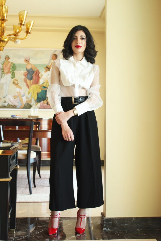 Tracy wears Elisabetta Franchi shirt, belt and pants with Christian Louboutin shoes