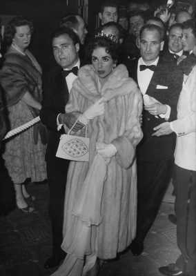 Hollywood royalty Elizabeth Taylor made quite an entrance in a tiara and a fur coat with husband Mike Todd.