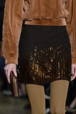 Even the most straightforward wardrobe ensemble, like a schoolgirl sweater and skirt, reveals various embellishments on closer inspection. The latter is embroidered with cognac bugle beads and the sweater is crafted from thick fur that’s shaved into a cable knit motif. Wear with ribbed knit tights and leather loafers for an academic look.