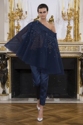Billowing, off-the-shoulder, ensign blue capes are reworked with lace and mesh embellishments