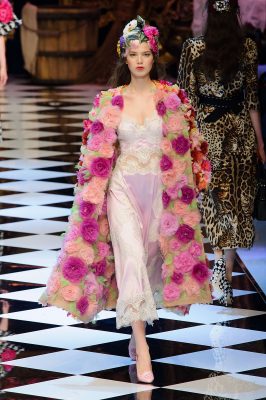 At Milan Fashion Week, Dolce & Gabanna’s duster coat boasts a variety of chunky fuchsia flowers, as if freshly plucked from an English rose garden. Underneath lays a sheer silk and satin baby pink evening dress.