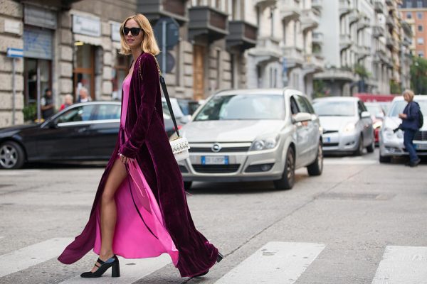 Candela Novembre wears a fuschia velvet coat over a neon pink slip dress.
