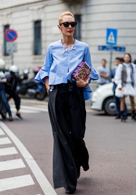 Elina Halimi plays with proportion sporting wide legged trousers and a bell-sleeved shirt.
