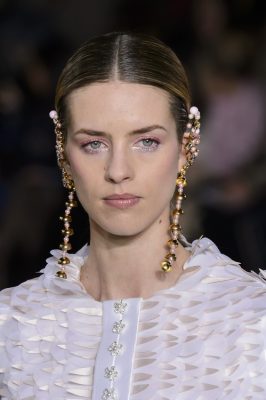Georges Hobeika. In a collection that focused on applique, shades of white and spindling gold ornamentation drew focus to the eye. However, unlike traditional mascara the eyes were lined in shimmering lavender, which was blended into exotic pink.