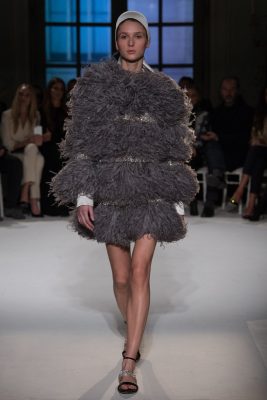Giambattista Valli: Part of a collection that displayed a true rendition of femininity, Giambattista Valli opted for a full feathered volume in charcoal grey balanced with delicate sequinned details and understated cuffs to tone down the effec
