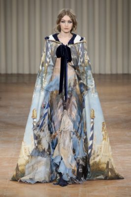 Alberta Ferretti: Venice-printed chiffon, gondolier stripes and plush velvet embroidery dominated angelic gowns and hooded capes at the Italian fashion designer’s latest show. Signature silhouettes and feminine tailoring remained a key focus, while midnight blue and beige fabrics were worn with delicate ribbons and satin detailing.