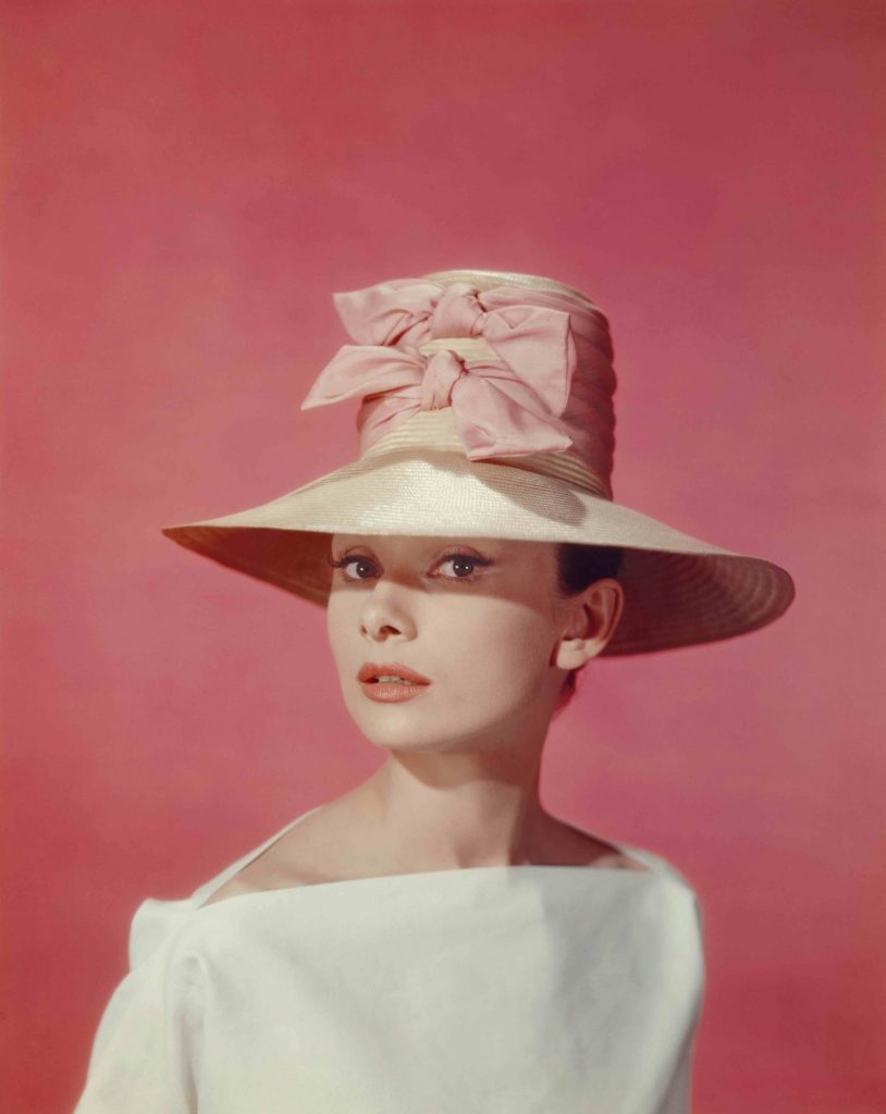 Hepburn became known for her oversized and wide-brimmed hats, pictured here in 1957. Image courtesy of Getty Images