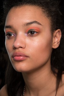 Backstage at House of Holland an unexpected range of hues were used on the eyes. Citrus shadow was worked around the parameters of a khaki green lid while a dab of sparkly pink shadow brought a glimmer to the inner eye with a hint of blue mascara to complete the look.