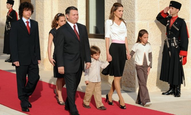 May 2009 | During a family outing in Amman, Queen Rania looks sophisticated and showcases her slender silhouette while escorting her two youngest children down the red carpet. A black, skater skirt and baby-pink belt is complemented by a draping, white mid-sleeved top.