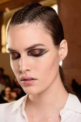 Balmain: Balmain's reimagined cat eye exudes avant-garde opulence. To recreate this look use a black gel liner from tear ducts over the lids and past the corners of the eyes. Then apply a coppery pigment shadow over he lids with a slightly damp brush. Finish by applying a contrasting metallic shade under the outer edge of lower with a thin brush.
