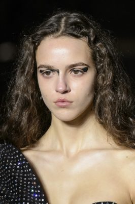 Saint Laurent: Tap into Saint Laurent's grungy beauty look by applying a black gel liner with messy brush strokes. Keep accompanying make up to a minimum.