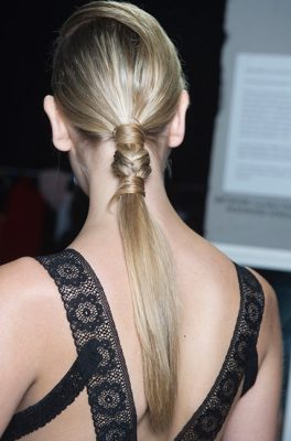 The polished pony: Try out Teatum Jones' sleek ponytail by pulling hair back towards the base of the head. Separate out a small section and wrap around the start of the ponytail. Fishtail braid a small section of the ponytail before wrapping the remaining end  of the loose strand around the end of the braid. Secure with an invisible elastic hair tie.