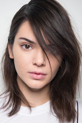 One sided: To emulate the Forties-style hair seen at Michael Kors, create an extreme side part on dry-shampooed hair. Use a bobby pin to tuck the smaller side back behind the ear and allow hair on the other side to fall gently in front of the face