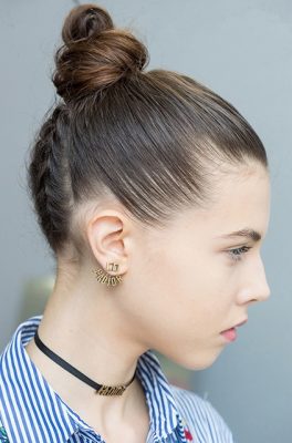 The refined top knot: At Dior, models sported tight braids that started at the nape of the neck and finished in an elegant top knot. To create this look, divide hair near the nape of the neck into four portions. Braid each portion pulling tight to secure. Continue the braids until just before the crown of the head and secure the end with an invisible hairband. Gather loose hair, twist into a bun and secure with bobby pins, lift braids upwards and wrap around the bun. Finish with a medium hold hairspray.