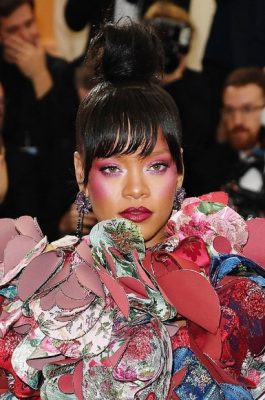 To make more of a statement look to Rihanna's voluminous top knot, tie a ponytail at the very top of the head and neatly wrap the hair around it. This looks works especially well with hairstyles cut with a front or side fringe
