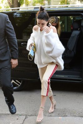 Track-inspired joggers were worn by Kendall Jenner, with an oversized jumper that featured a V-neck design. Crème caramel-coloured suede sandals complemented the neutral-hued separates, which were elevated by polished aviator-styled shades and a colourful clutch.