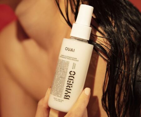 Model holds Ouai x Byredo Leave-In Conditioner