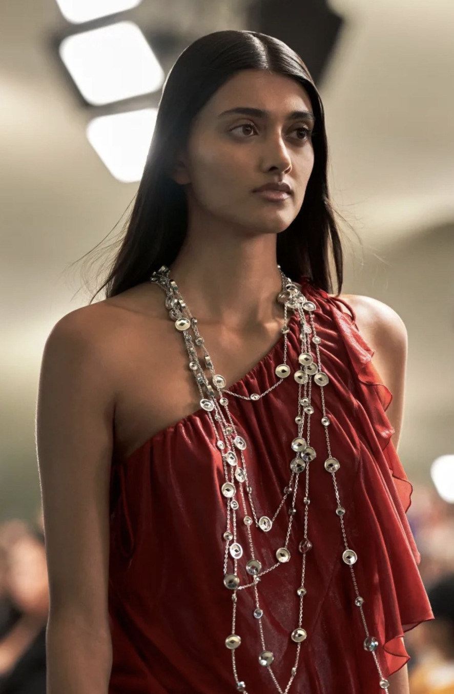 woman in red dress long necklaces